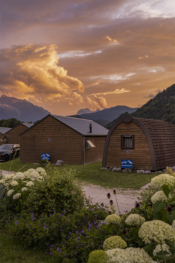 Holzhütten und Hortensien unter Abendwolken