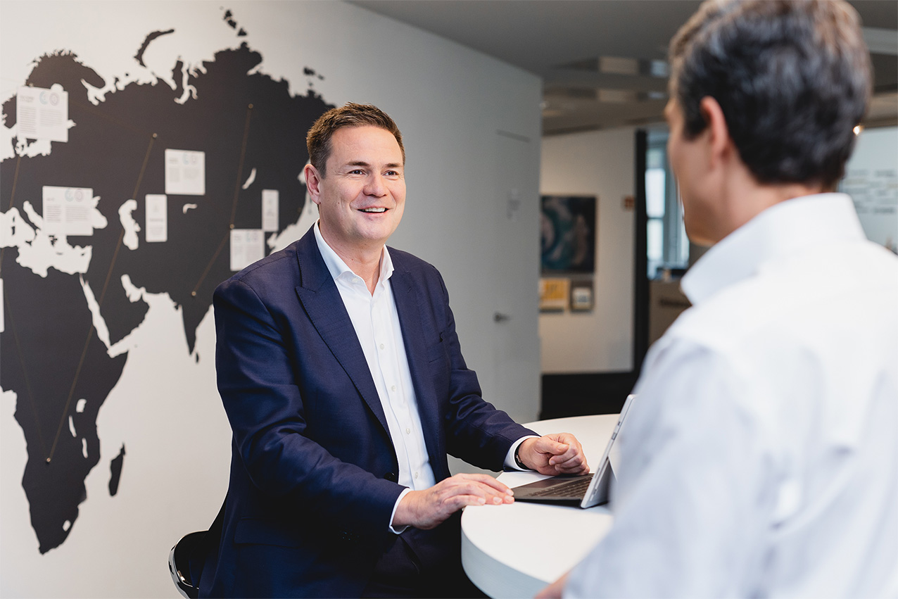 Werner Hedrich im Gespräch vor der Weltkarte im Büro