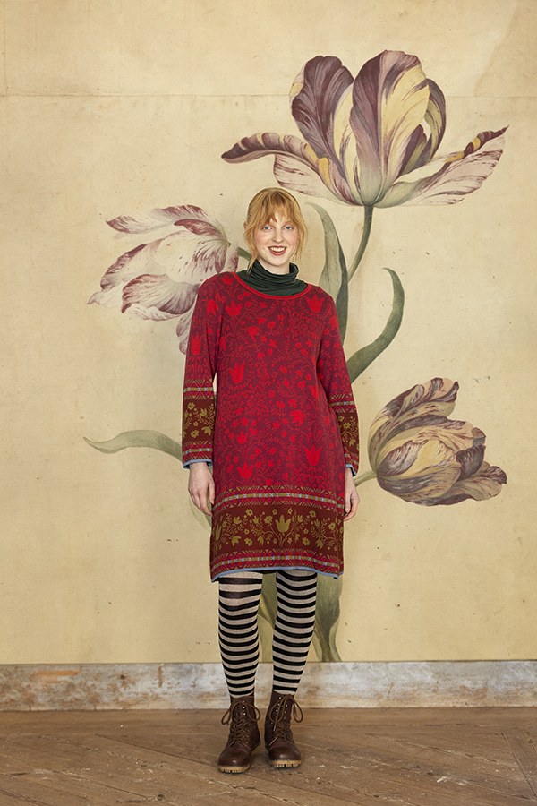 Modell im roten Strickkleid vor einer Tulpenmalerei
