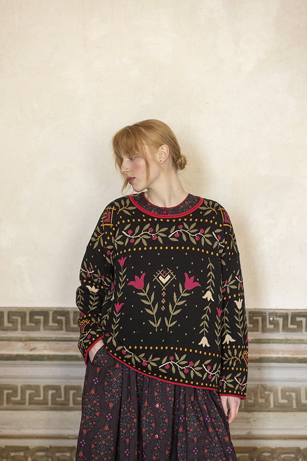 Modell im schwarzen Pullover mit bestickten Mustern