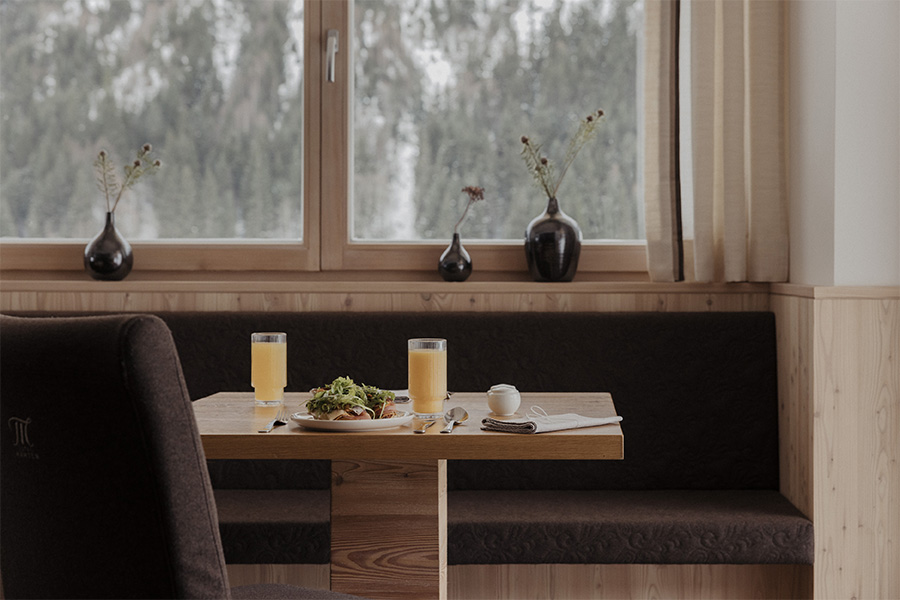 Gedeckter Frühstückstisch am Fenster mit Blick in den Schnee