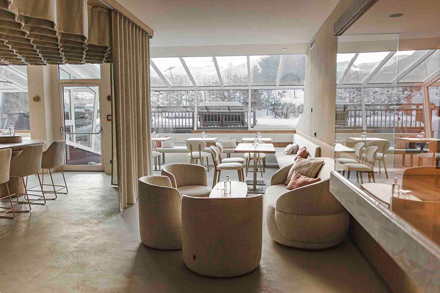 Café mit runden Sesseln und großen Fenstern
