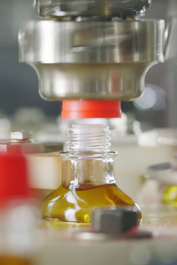 Abfüllanlage verschließt eine Glasflasche