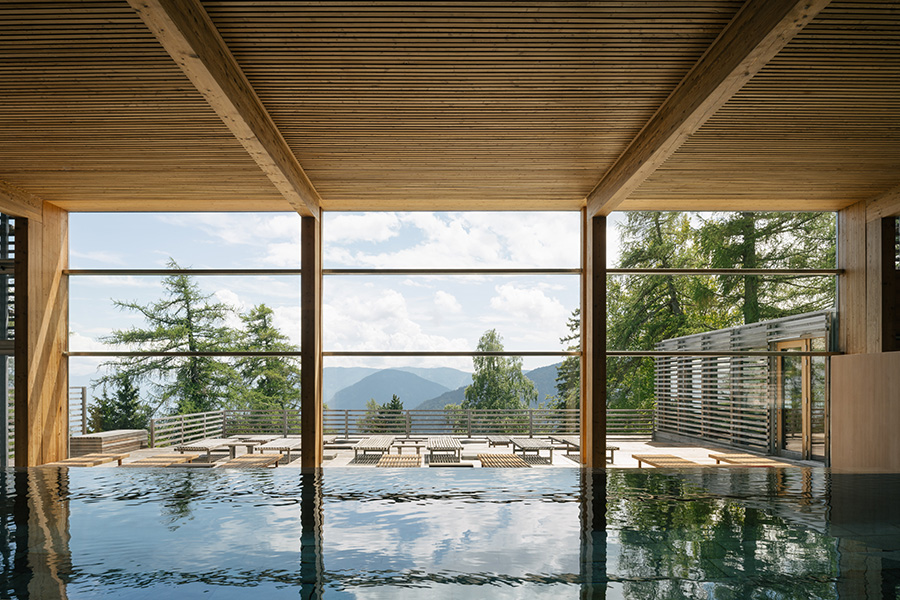 Innenpool mit Blick durch die Glasfront in die Berge